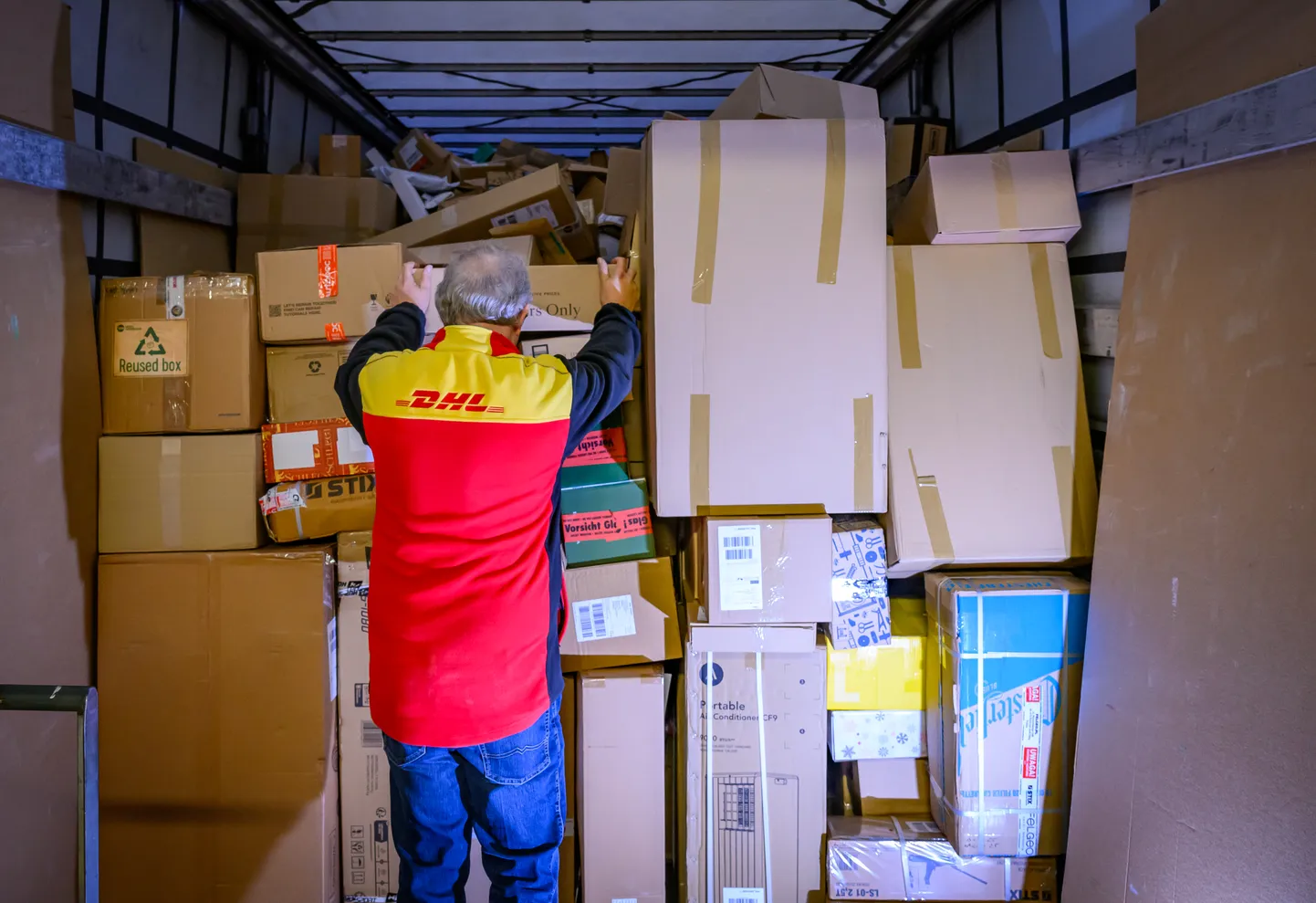 DHL töötaja pakke laadimas.