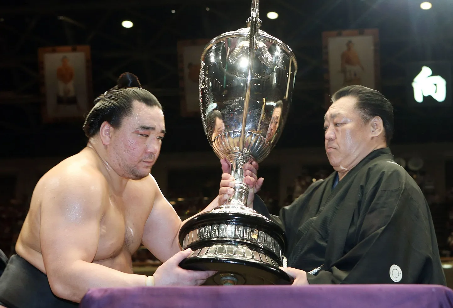 Harumafuji (vasakul) võidukarikat vastu võtmas.
