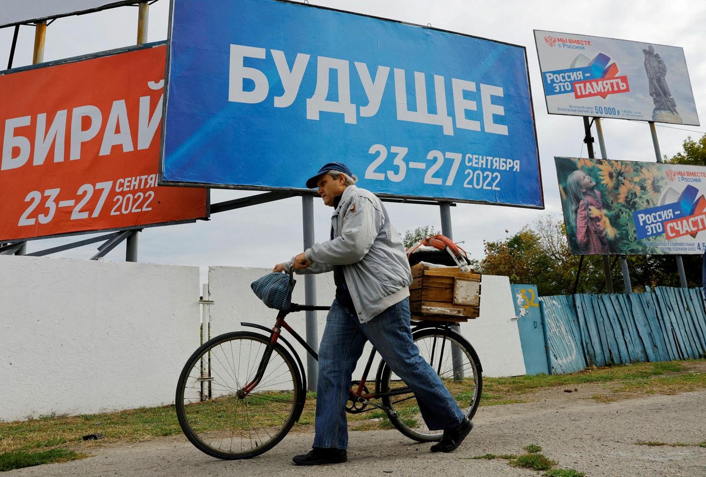 Mees möödub Zaporižžja oblastis Melitopolis plakatist, mis teavitab Venemaa kontrollitud alal toimuvast rahvahääletusest.