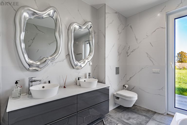 Ванную украшают дизайнерские зеркала необычной формы.