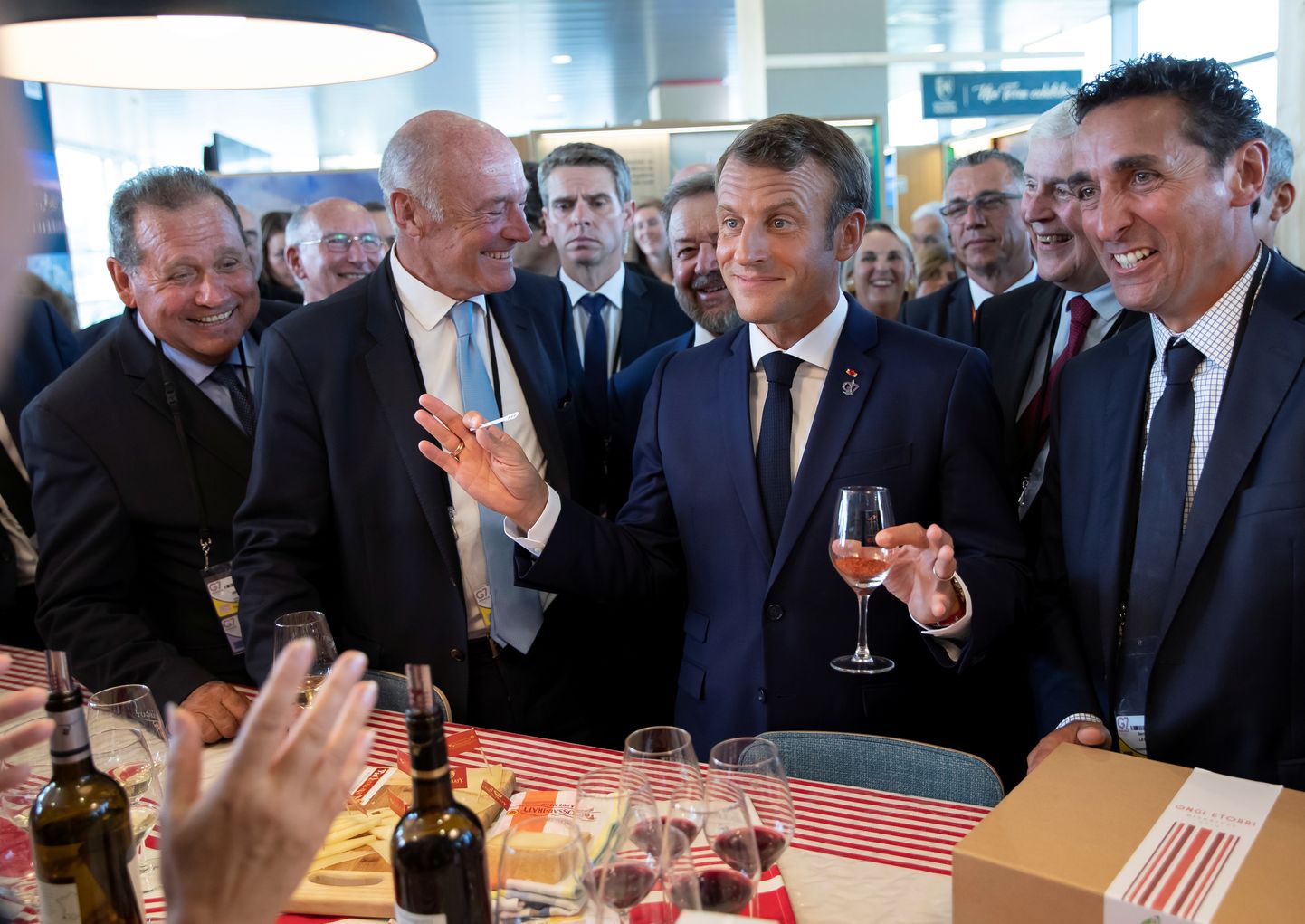 Prantsuse president Emmanuel Macron (keskel) maitsmas Prantsuse veine G7 tippkohtumise avapäeval rahvusvahelise pressikeskuse kohal olevas näitustesaalis.