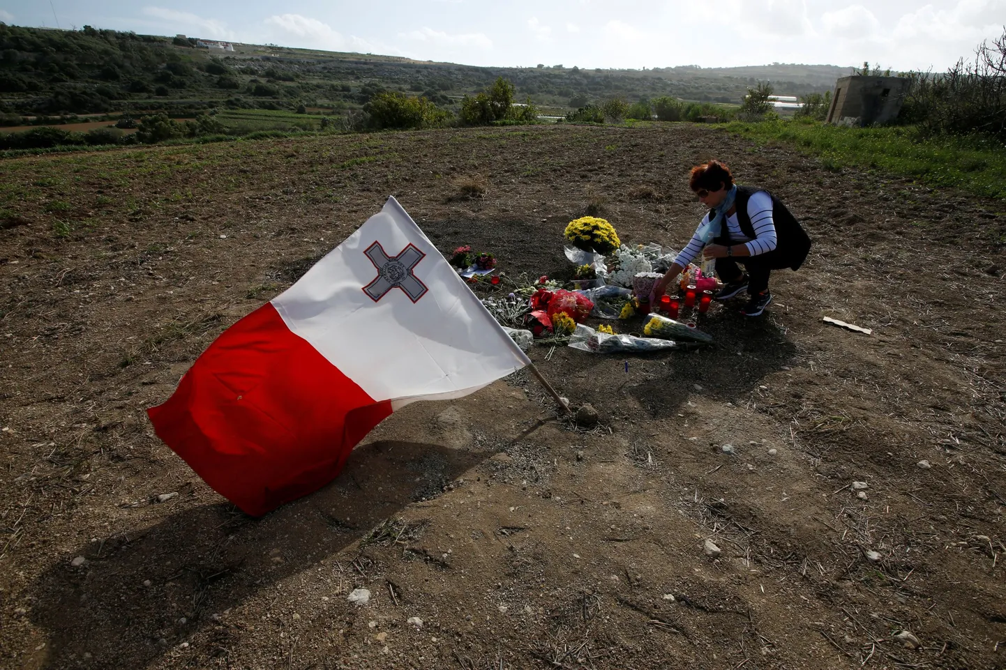 Naine viimas lilli Daphne Caruana Galizia mõrvapaika.