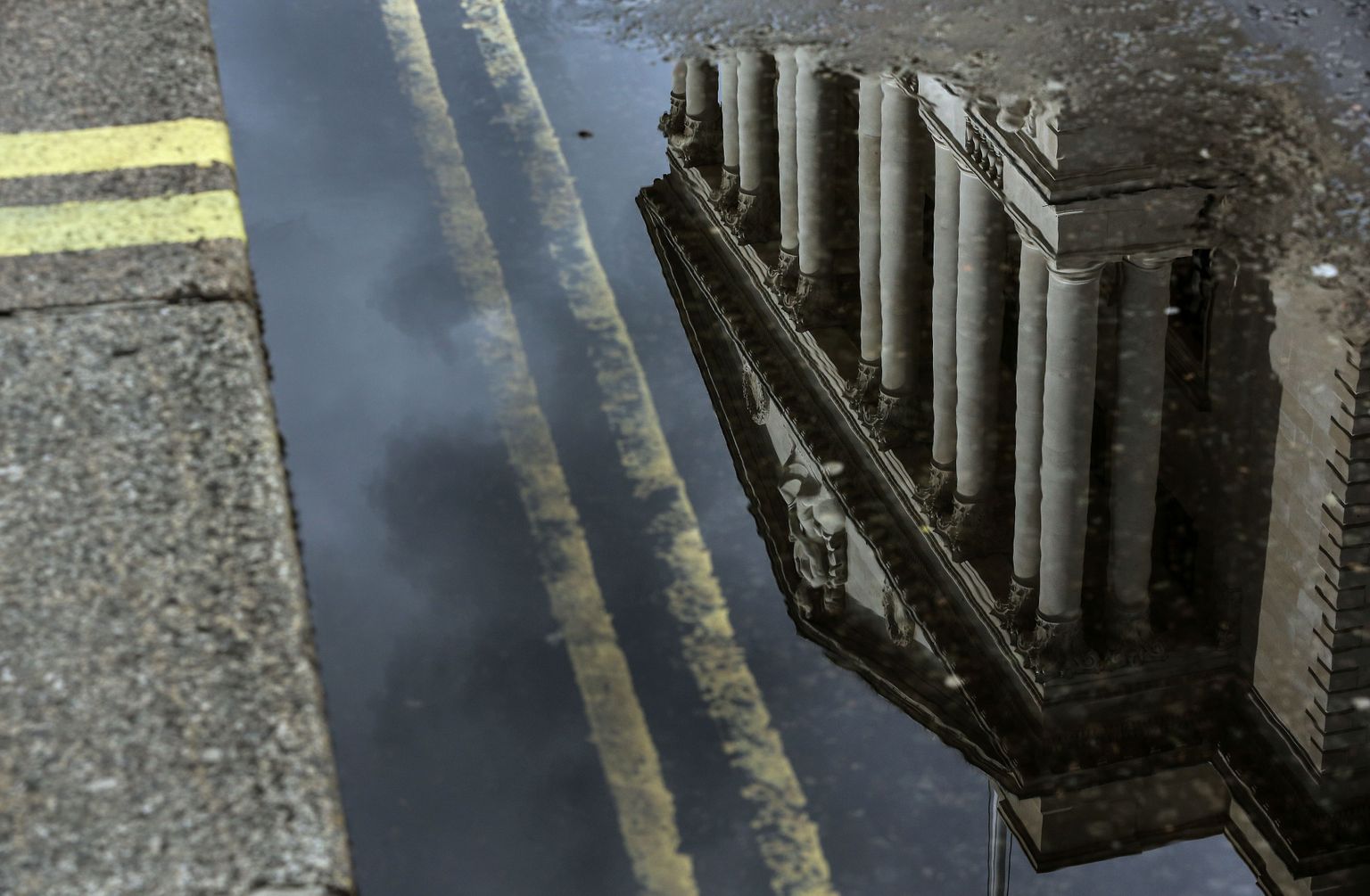 Suurbritannia keskpanga hoone peegeldus vihmaveeliugus.