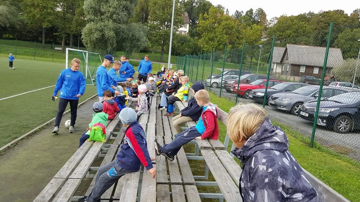 Viljandi jalgpalliklubi Tulevik esindusmeeskonnas pallivad mängijad jagavad klubi jalgpallikooli noortele helkureid.