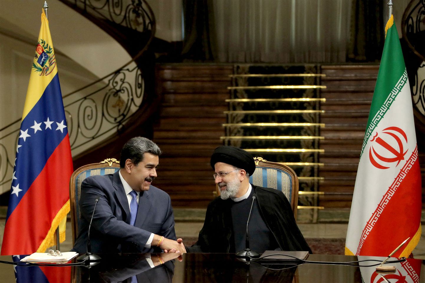 Iraani president Ebrahim Raisi (paremalt) ja Venezuela president Nicolas Maduro kätt surumas.