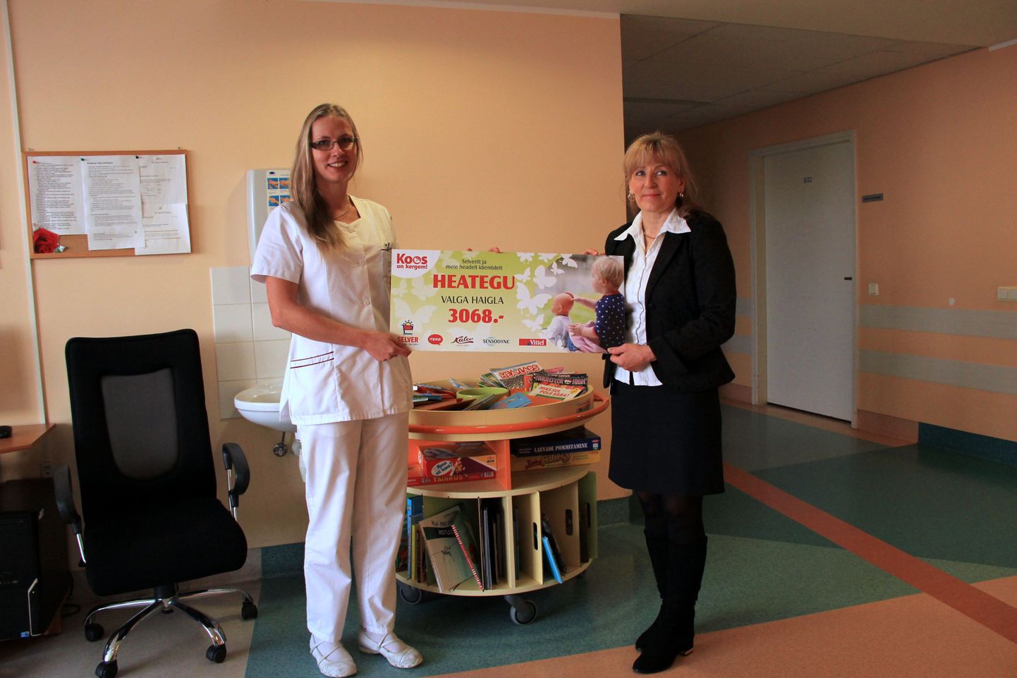 Valga haigla ravijuhile Kristel Kivisillale (vasakul) annab kampaaniaga kogutud toetussumma tšeki üle Valga Selveri juhataja Esta Järve.