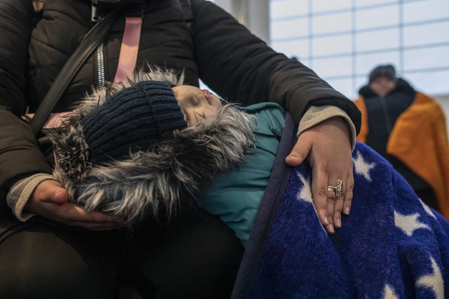 Трехлетний мальчик на руках у матери после выезда из Украины, Польша, март 2022 года.