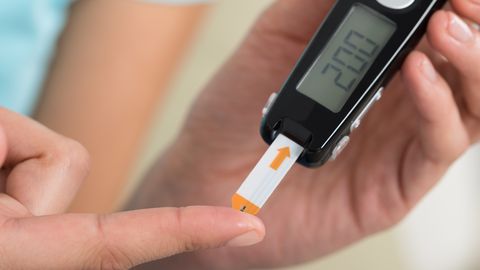 Woman Checking Blood Sugar Level Woman Checking Blood Sugar Level
