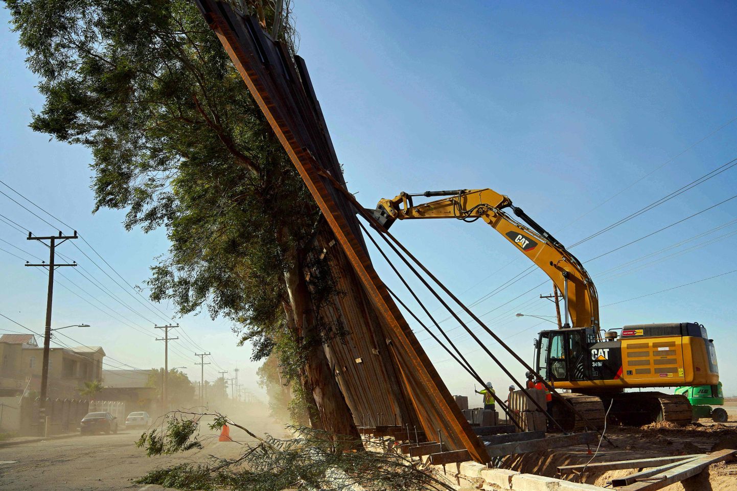 Ehitustöölised toestamas eile tuules viltu vajunud terasest piiritara USA ja Mehhiko piiril Calexico ja Mexicali linna vahel.