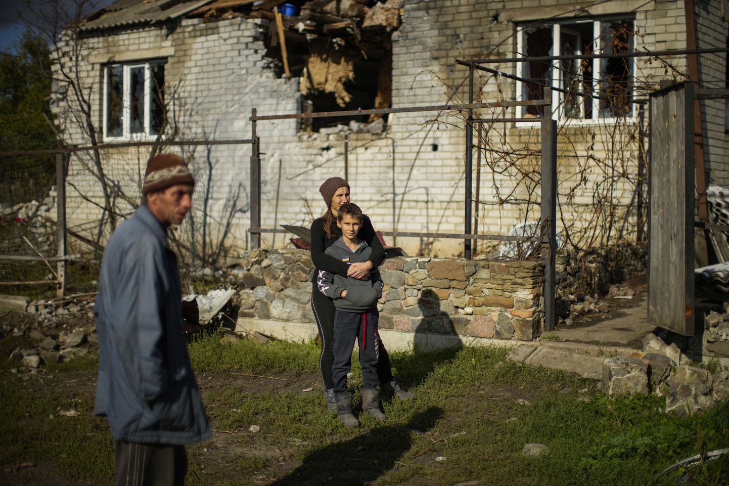 Perekond oma tabamuse saanud kodu ees seismas Shandrõgolovo külas Lõmani külje all.