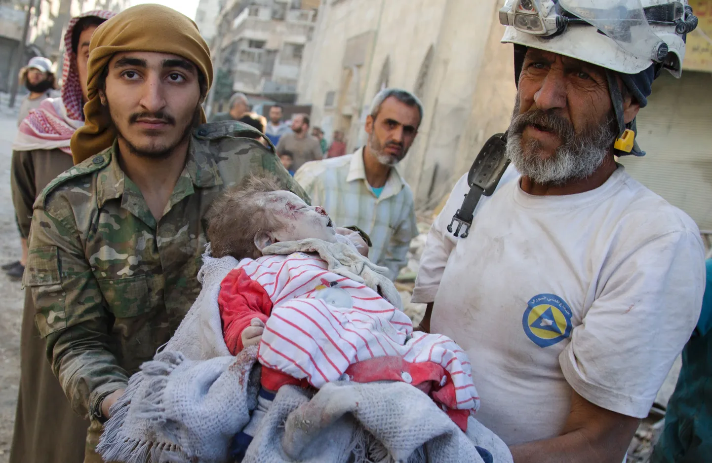 Valged Kiivrid kandmas Süüria Aleppo linna majarusudest välja kaevatud tüdruku keha.