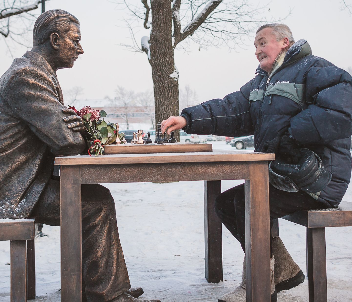 Leonid Belov istub 2016. aasta jaanuaris Narva kesklinnas malelaua taga, mille teisel pool on samas linnas sündinud Eesti malelegendi Paul Kerese kuju.