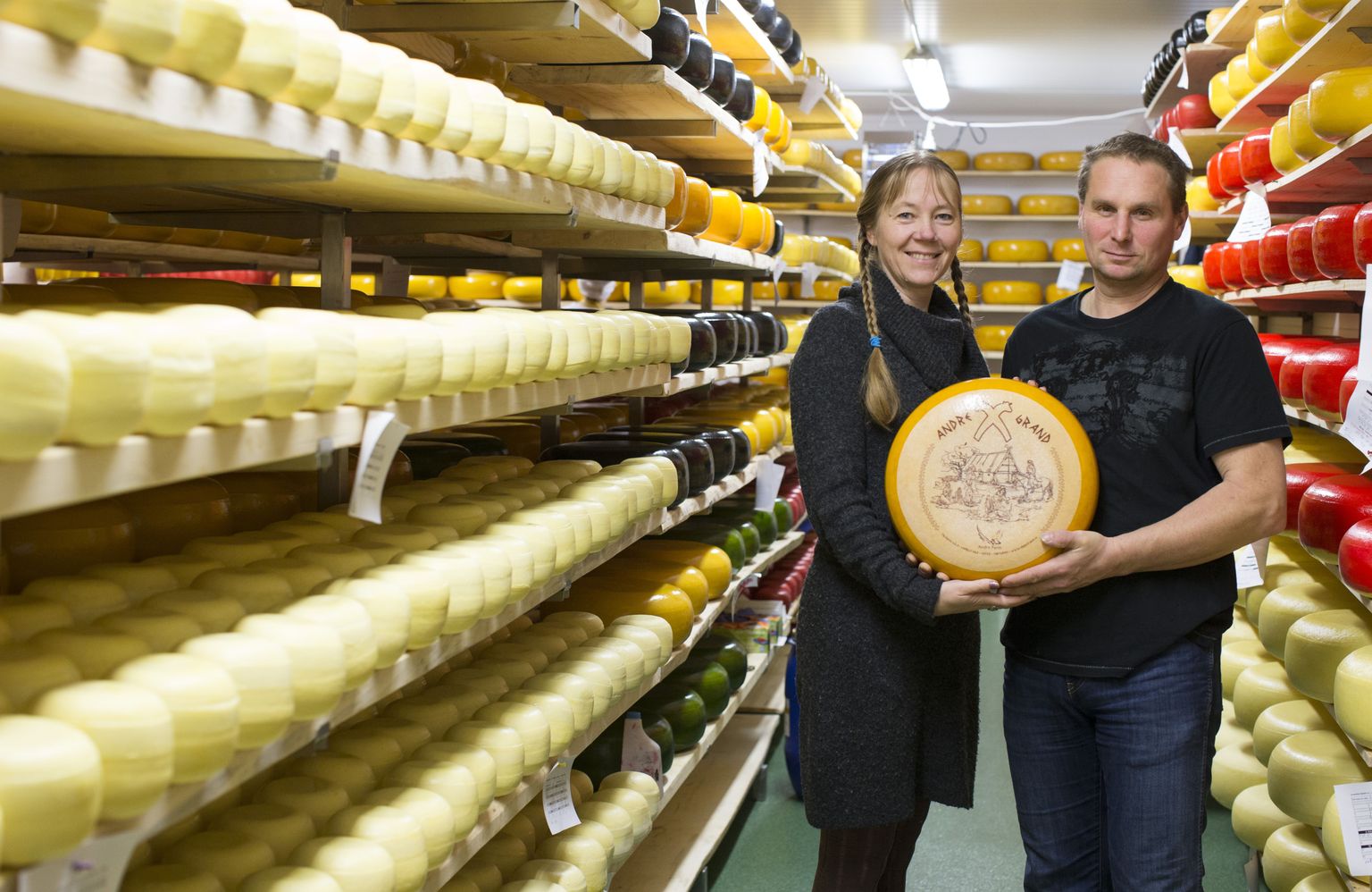 Laagerdusruumis: juustutalu perenaine Erika Pääbus ja peremees Aivar Alviste hoiavad käes üht oma meierei uhkust, Andre Grandi juusturatast. Puitriiulitel küpseb ja kogub maitset 27 tonni nooremat juustu.