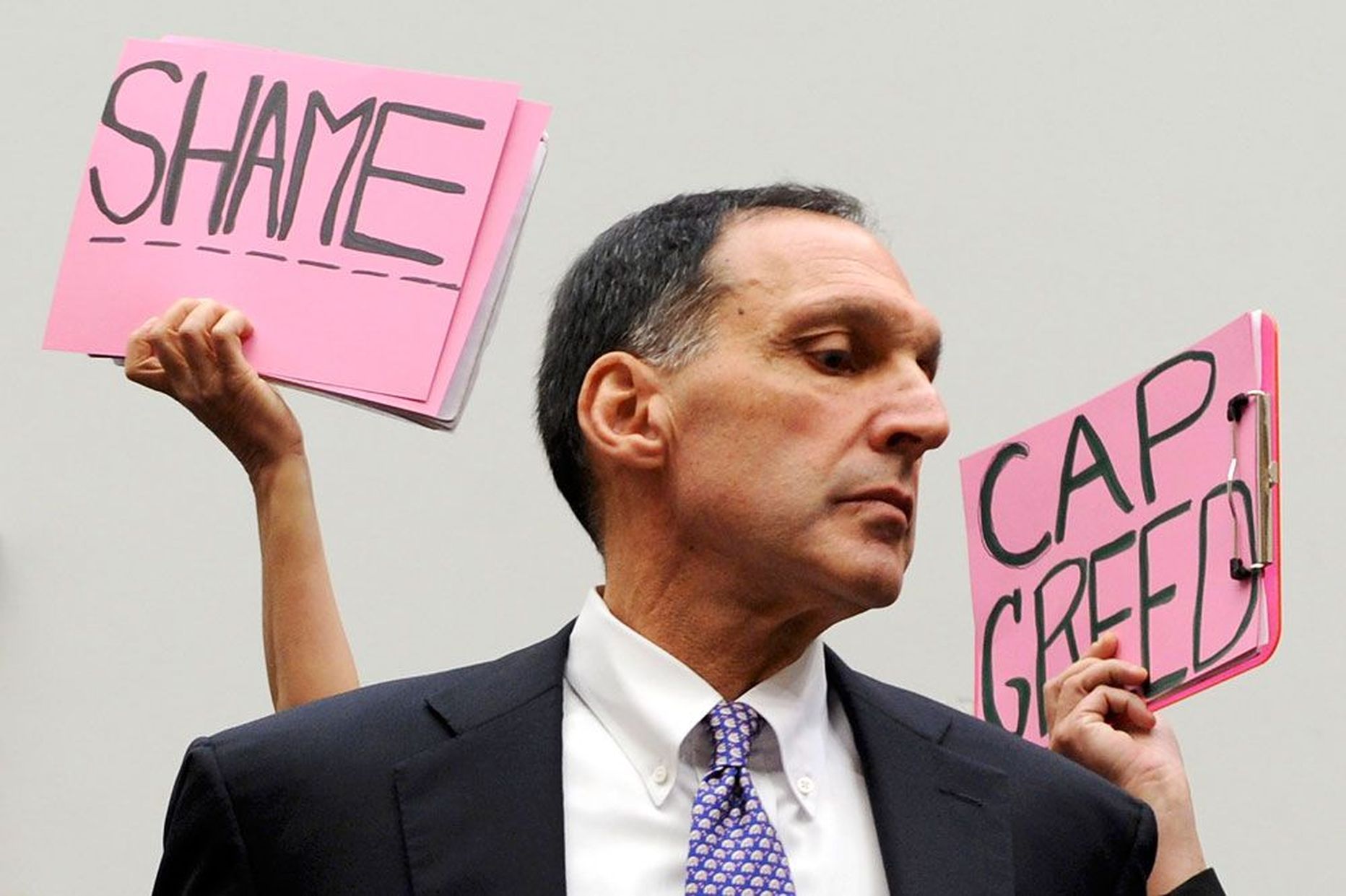 Lehman Brothersi juht Richard Fuld 2008. aastal meeleavaldajate protestiplakatite ees.