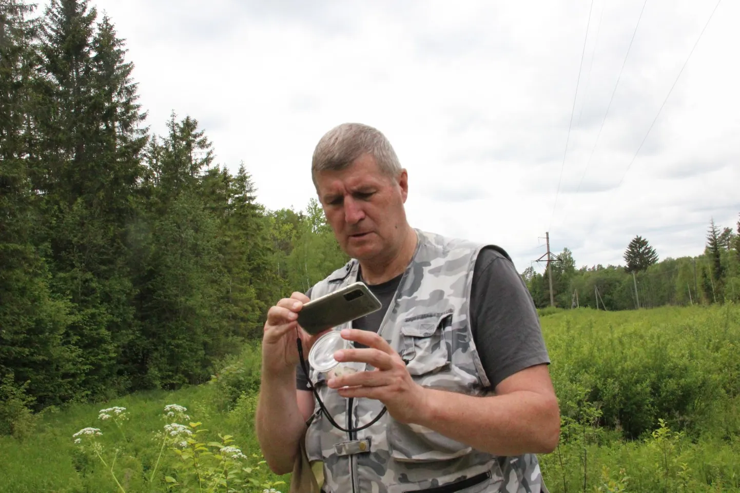Bioloog ja loodusfotograaf Urmas Tartes näitab lastele, kuidas määrata putukaid.