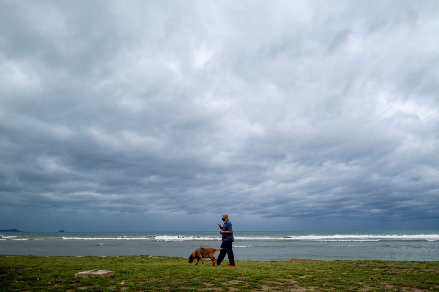 Mees jalutab oma koeraga, samal ajal kui troopiline torm Fiona ja selle tugevad vihmad lähenevad Puerto Ricole.