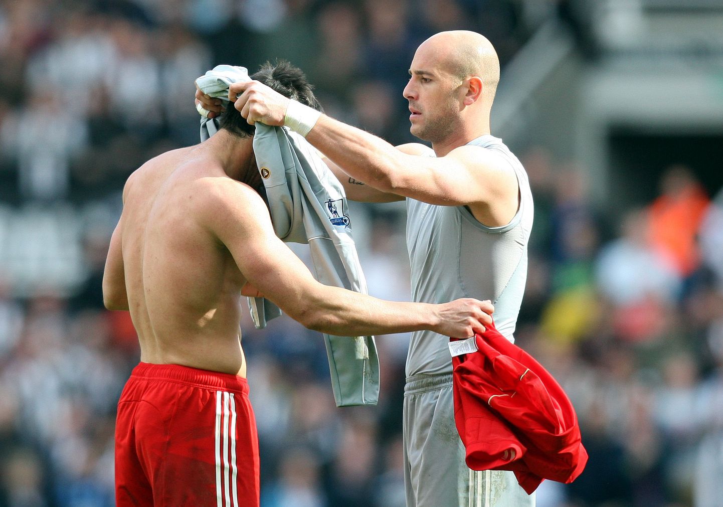 Liverpooli puurilukk Pepe Reina (paremal) annab oma varustuse Jose Enrique'le.