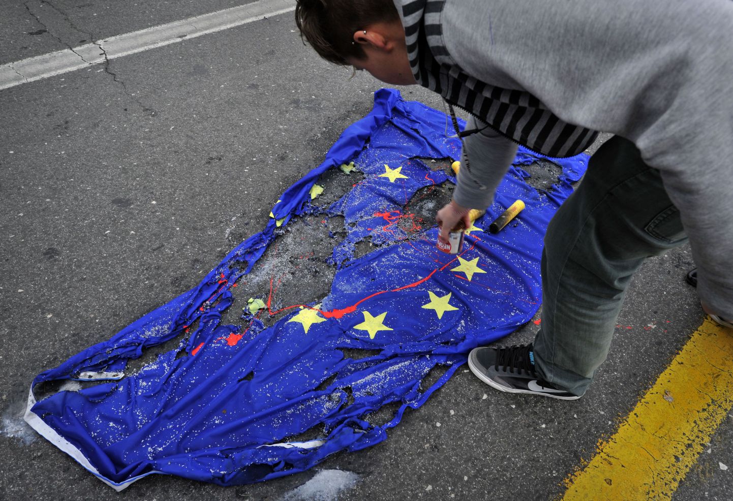 Kreeka tudeng meeleavaldusel ELi lipule punast värvi peale kallamas.