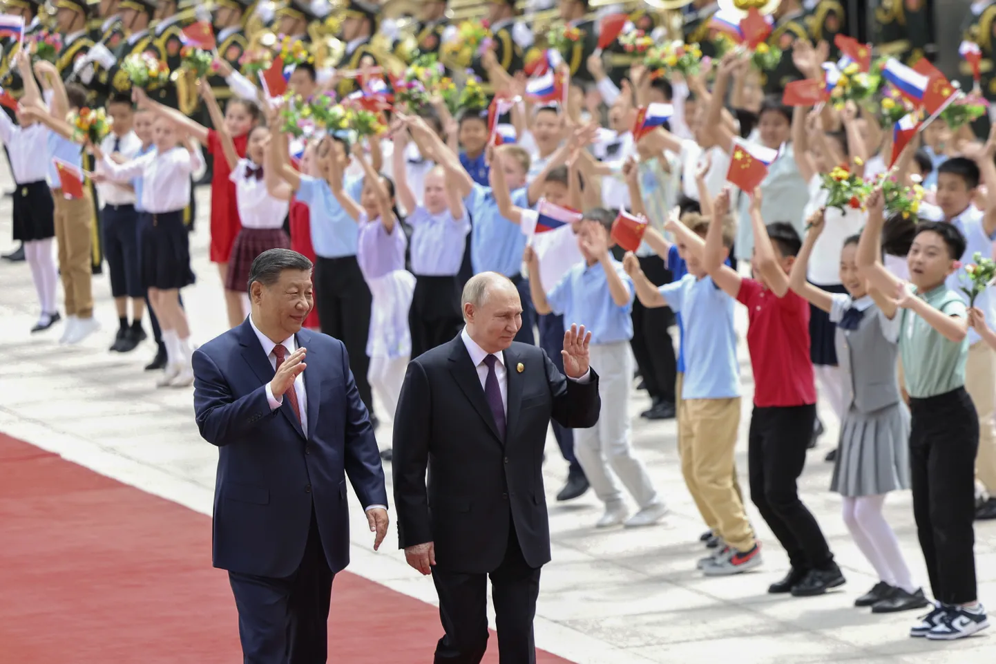 Hiina president Xi Jinping ja Vene ametivend Vladimir Putin 16. mail Pekingis lippudega laste eest möödumas.