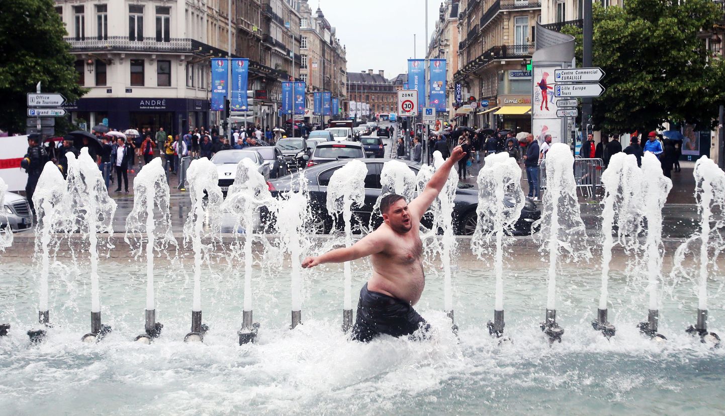 Футбольный болельщик купается в фонтане города Лилль.