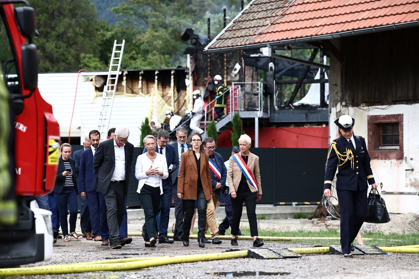 Peaminister Élisabeth Borne (keskel valges) takseeris põlenguala ja vestles kohalike ametnikega.