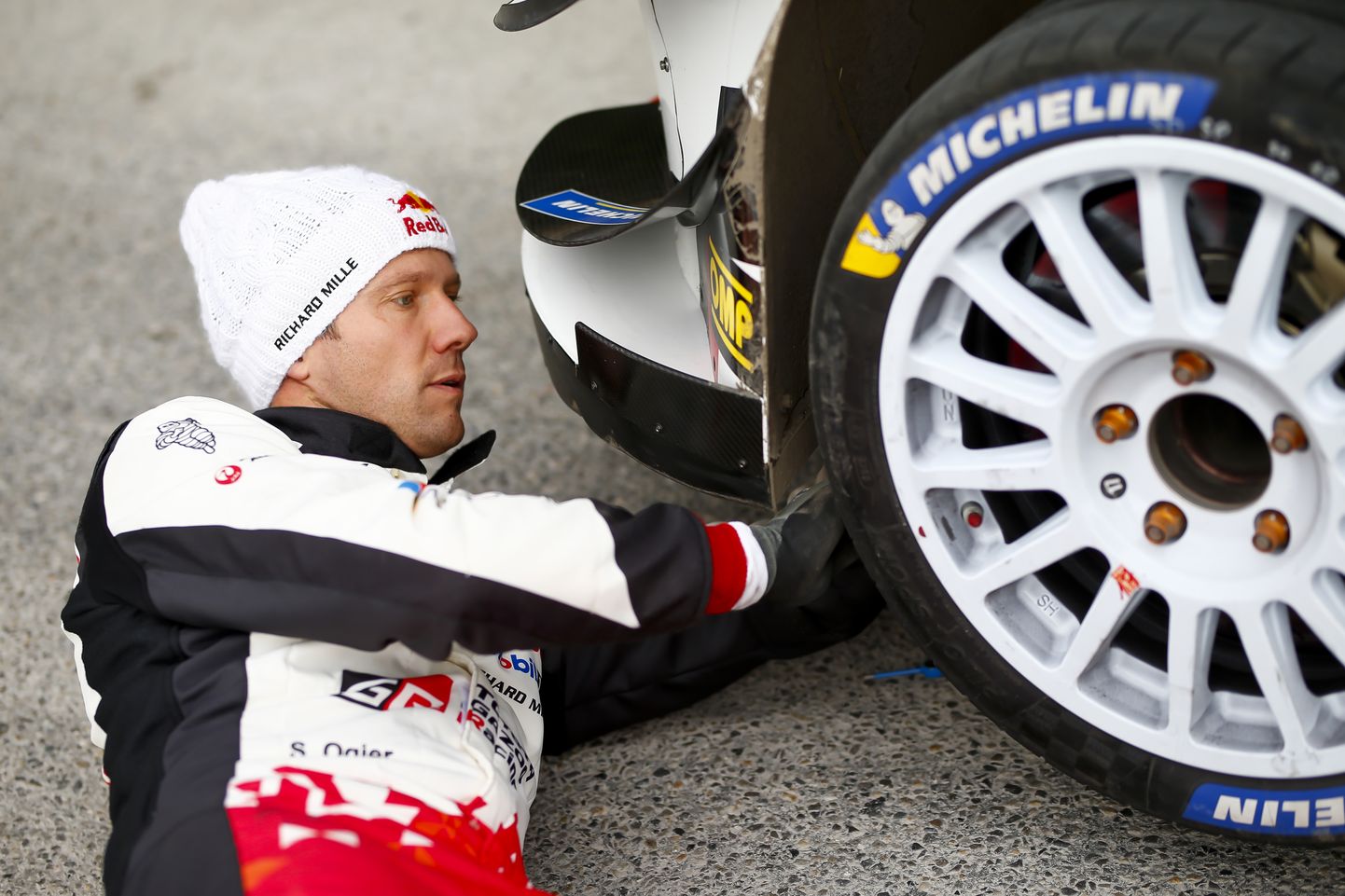 Sebastien Ogier oma Toyota Yaris WRC-auto rehve vahetamas.
