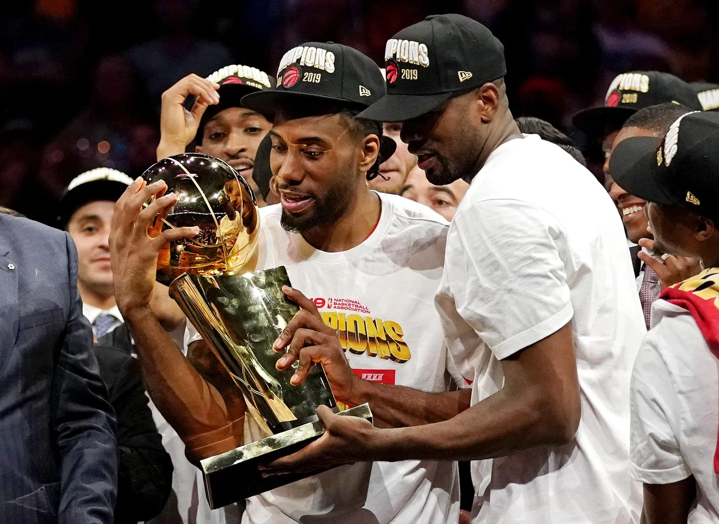 Kawhi Leonard (keskel) imetlab võidukarikat koos Serge Ibakaga.