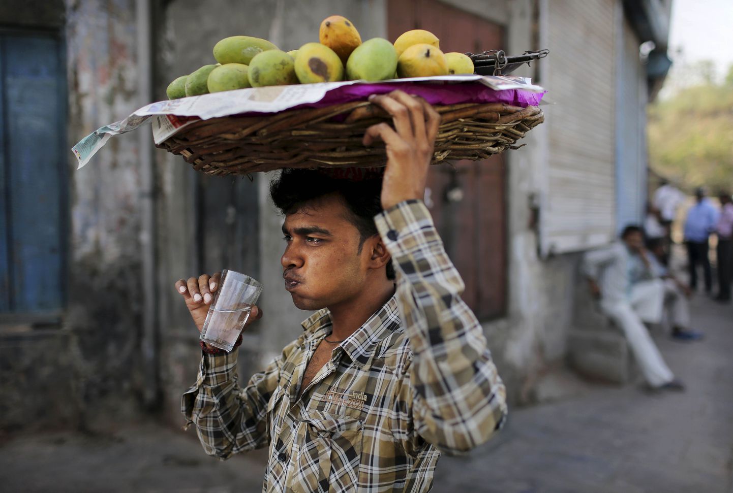 India mangomüüja klaasikest vett joomas