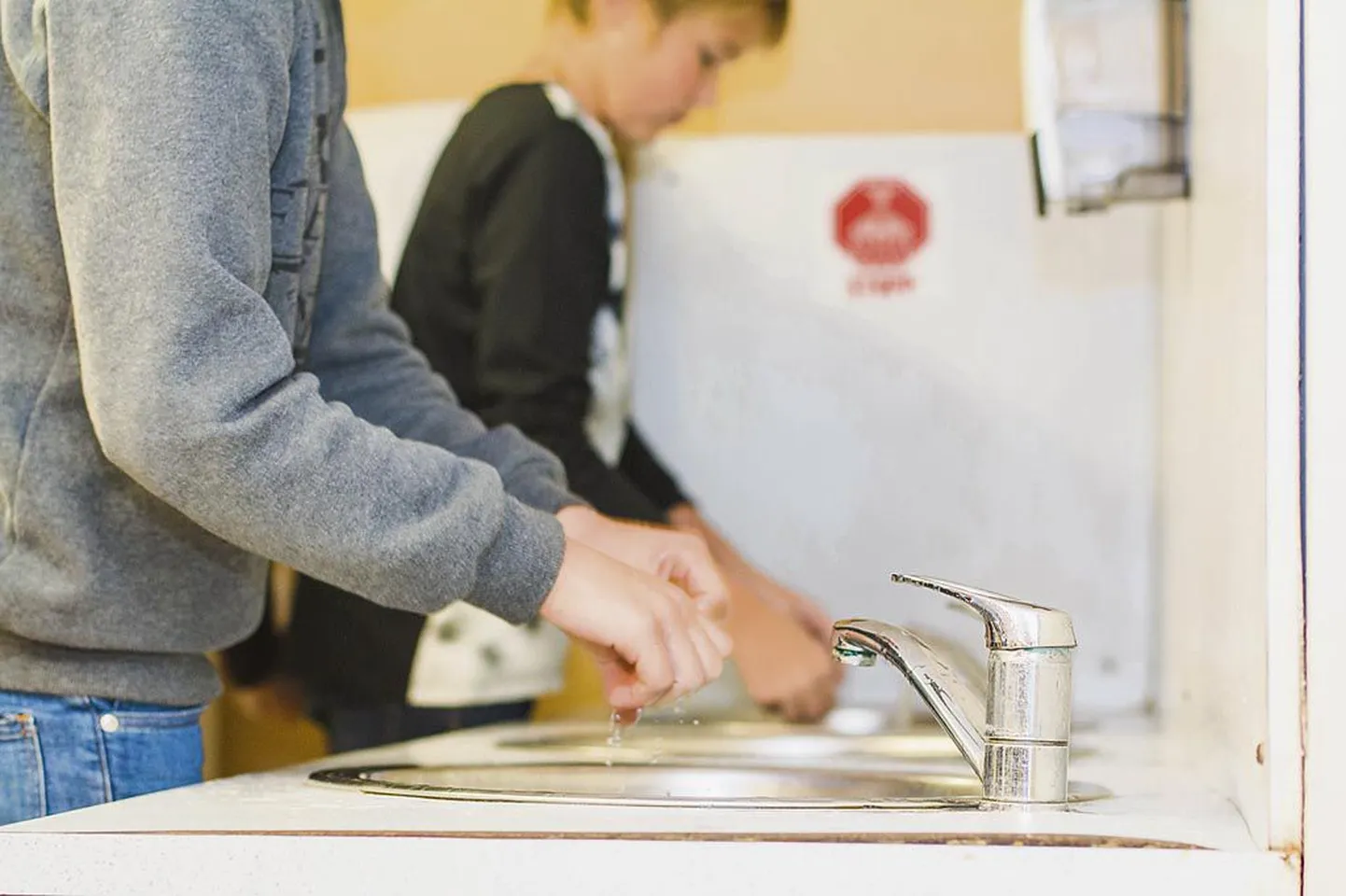 Pärnu Kuninga tänava põhikoolis meenutab punane silt sööklaesiste kraanikausside kohal õpilastele käte pesemise vajadust. Koolipere kinnitab, et enne vee ja seebiga käsi pesemata naljalt sööma ei minda.