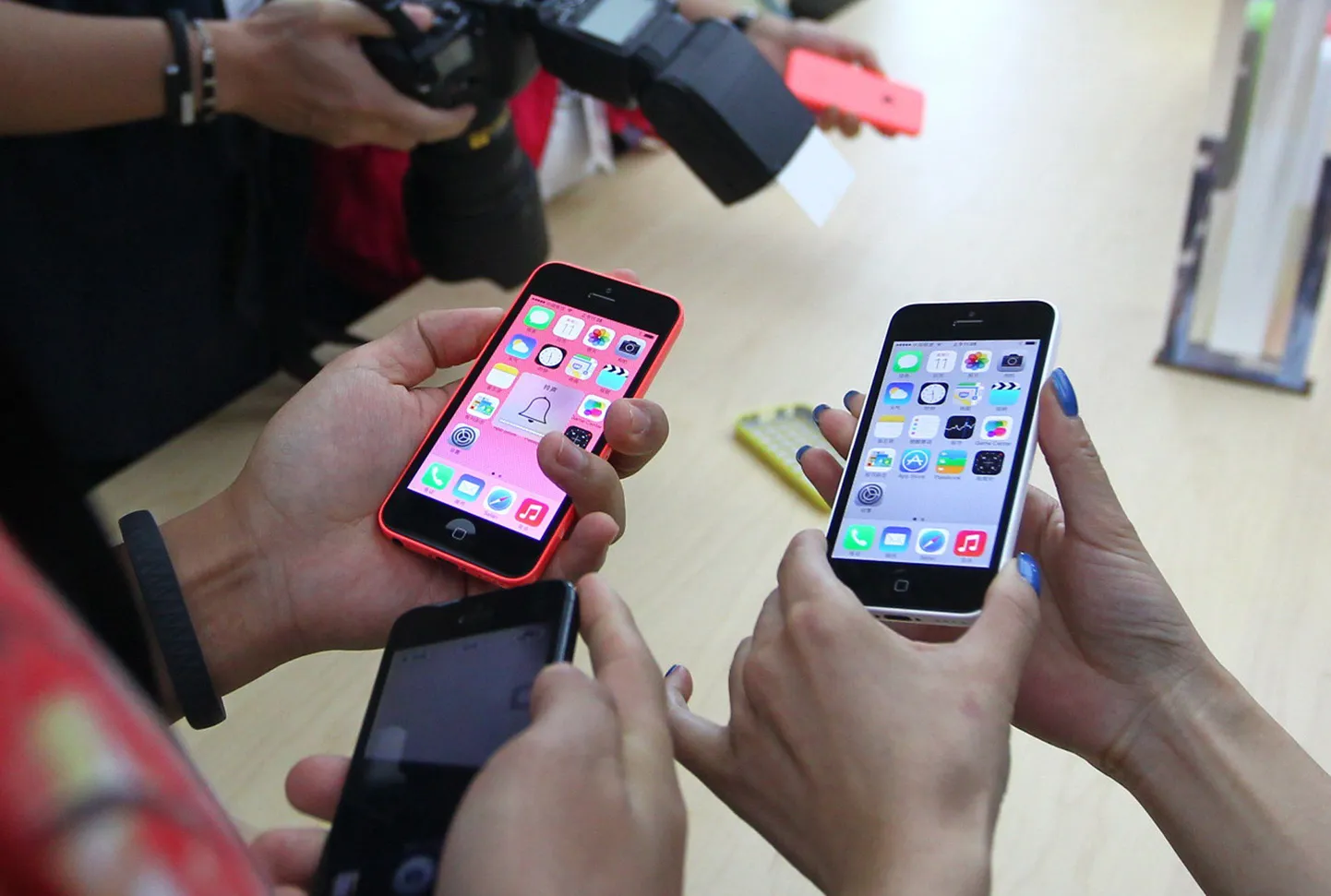 Ajakirjanikud näppimas iPhone'i eile Pekingis toimunud Apple'i pressikonverfentsil.