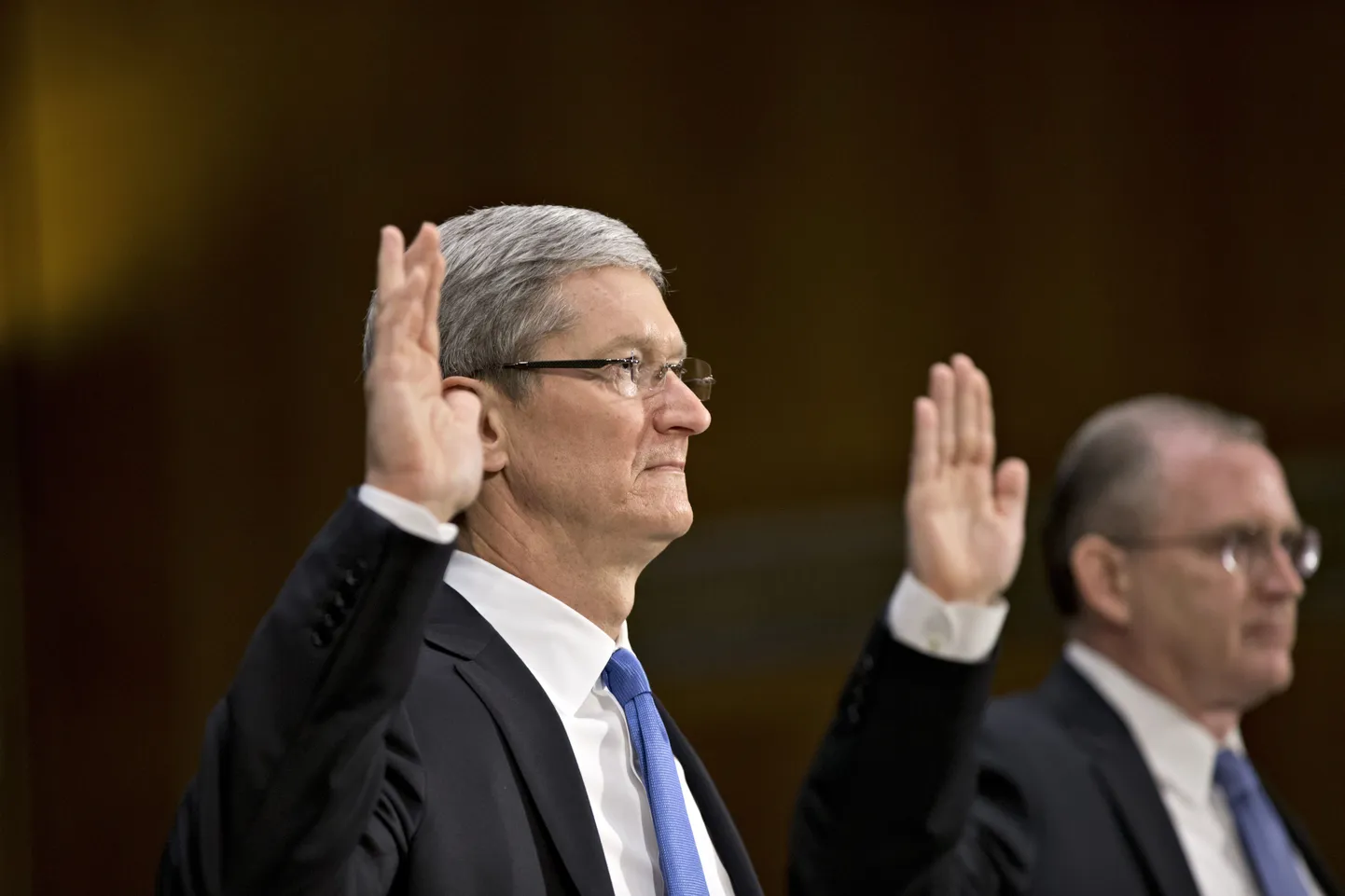 Apple tegevjuht Tim Cook (vasakul)ja maksuoperatsioonide juht Phillip A. Bullock (paremal)enne senaatorite arupärimist vannet andmas.