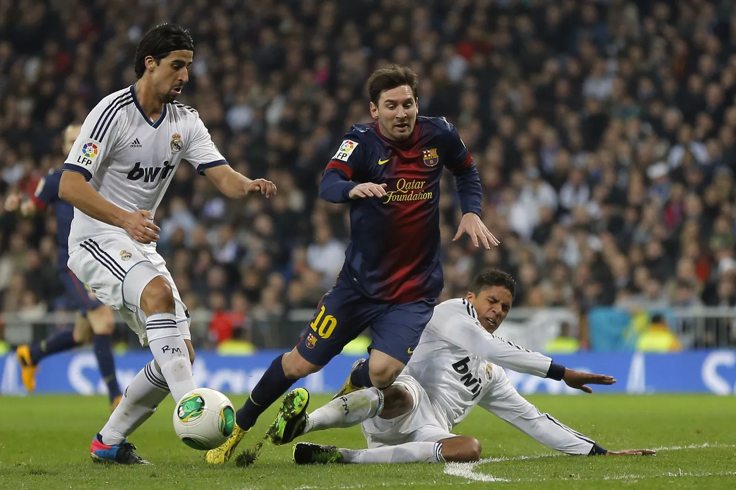 Raphael Varane (pikali) Lionel Messit takistamas