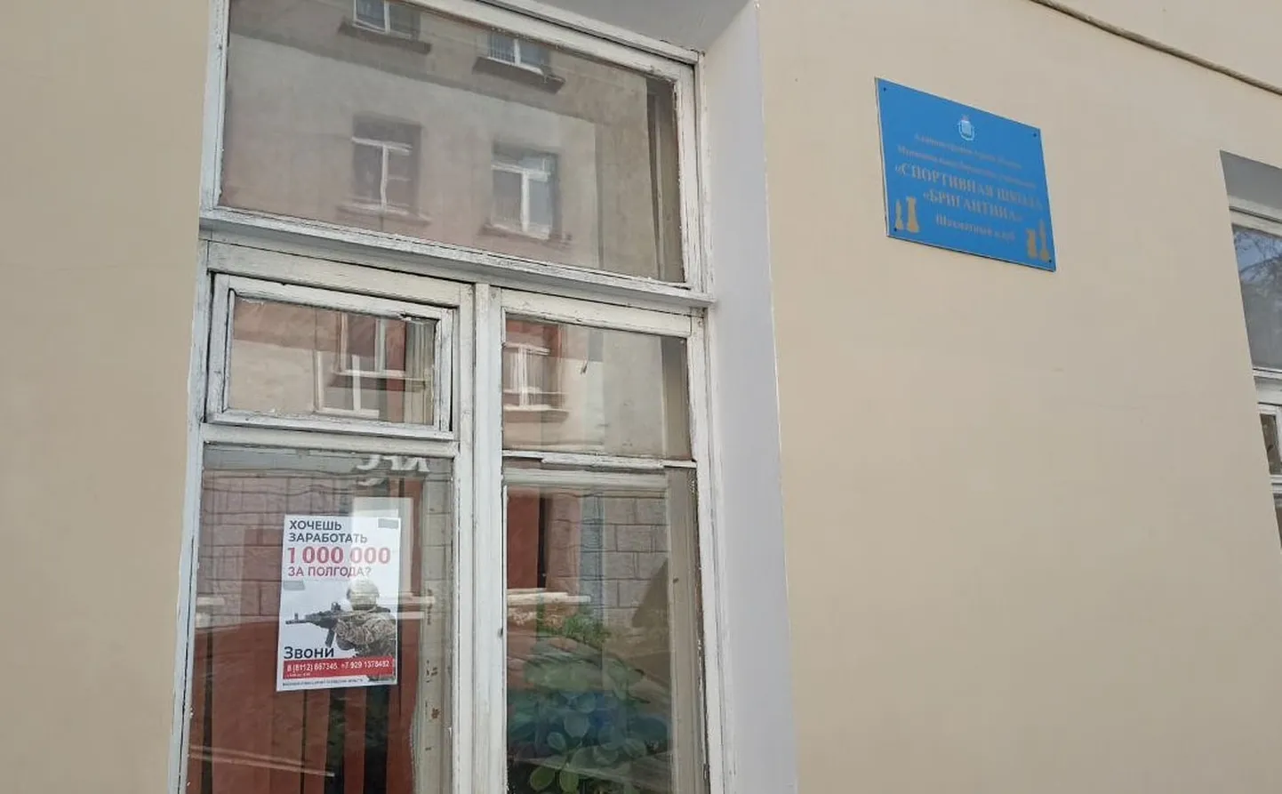 Кампания по призыву людей на войну на окне спортивной школы в Пскове.
