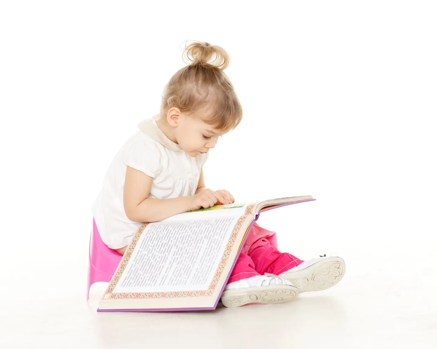 Pretty little girl sits on potty.