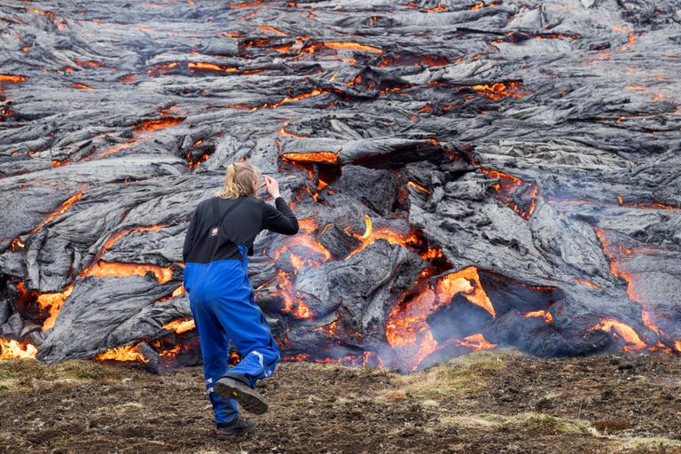 Mees jäädvustamas Islandi Fagradalsfjälli vulkaani laavavoolu