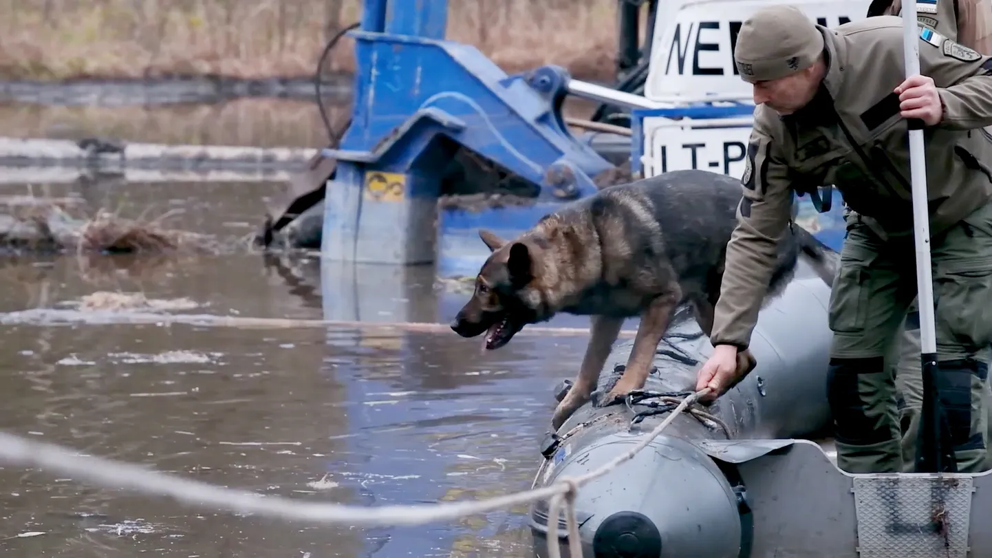 Maik, who is searching for a U.S. soldier in Lithuania, and dog handler Risto Kotkas.