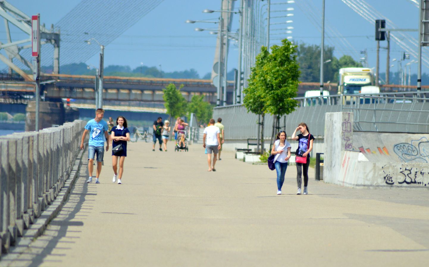 Cilvēki pastaigājas Daugavas promenādē