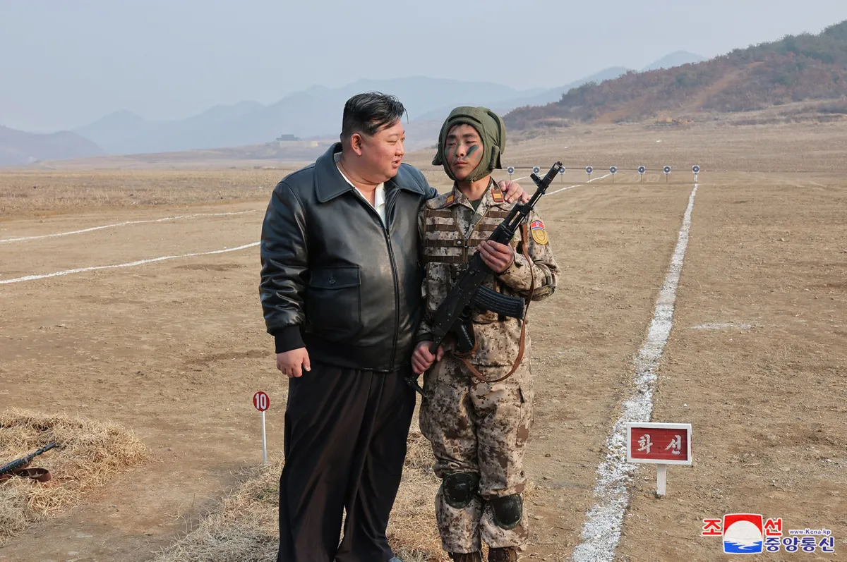 Picture taken on March 15, 2024 and released from North Korea's official Korean Central News Agency (KCNA) on March 16 shows North Korean leader Kim Jong Un (L) encouraging a soldier during a training of the Korean People's Army at an undisclosed location in North Korea.