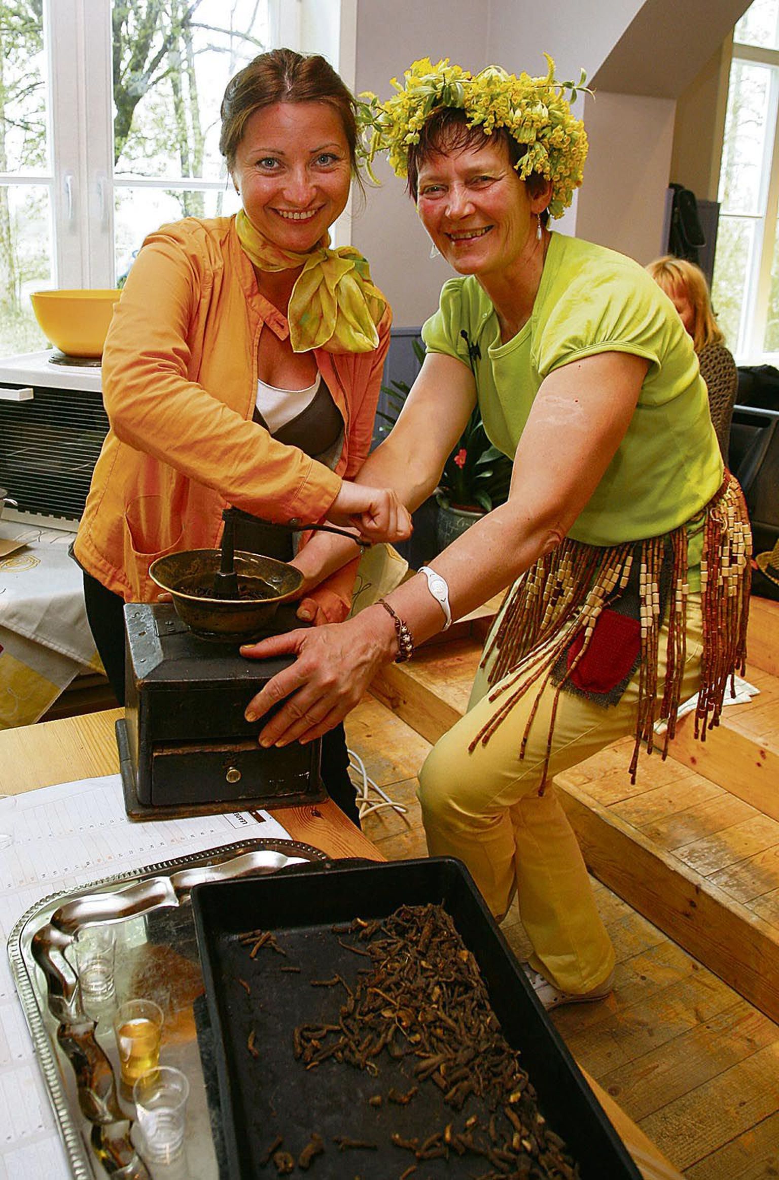 Mercedes Merimaa (paremal) ja Marina Merimaa iidvana kohviveskiga võilillejuuri jahvatamas.