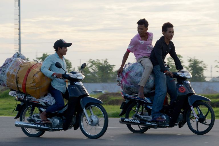 Noormehed sõidavad mööda Phnom Penhi tänavat. / Scanpix