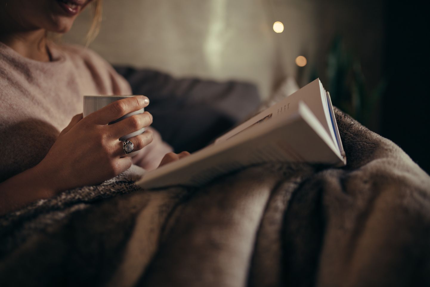 Женщина читает в постели книгу. Иллюстративное фото.