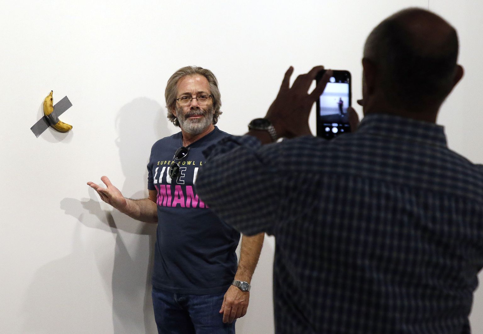 Itaalia kunstnik Maurizio Cattelan poseerimas 2019 USAs Floridas Miamis oma banaaniteose «Comedian» («Koomik») juures
