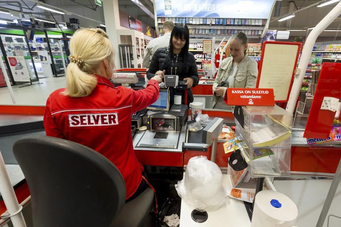 Männimäe Selveri kassas ostjaid teenindav Thea Muttel ja tema ametikaaslased hoiavad kilekotihunnikut enda juures ning kunde peab tasuta pisikest kilekotti kassapidajalt küsima.