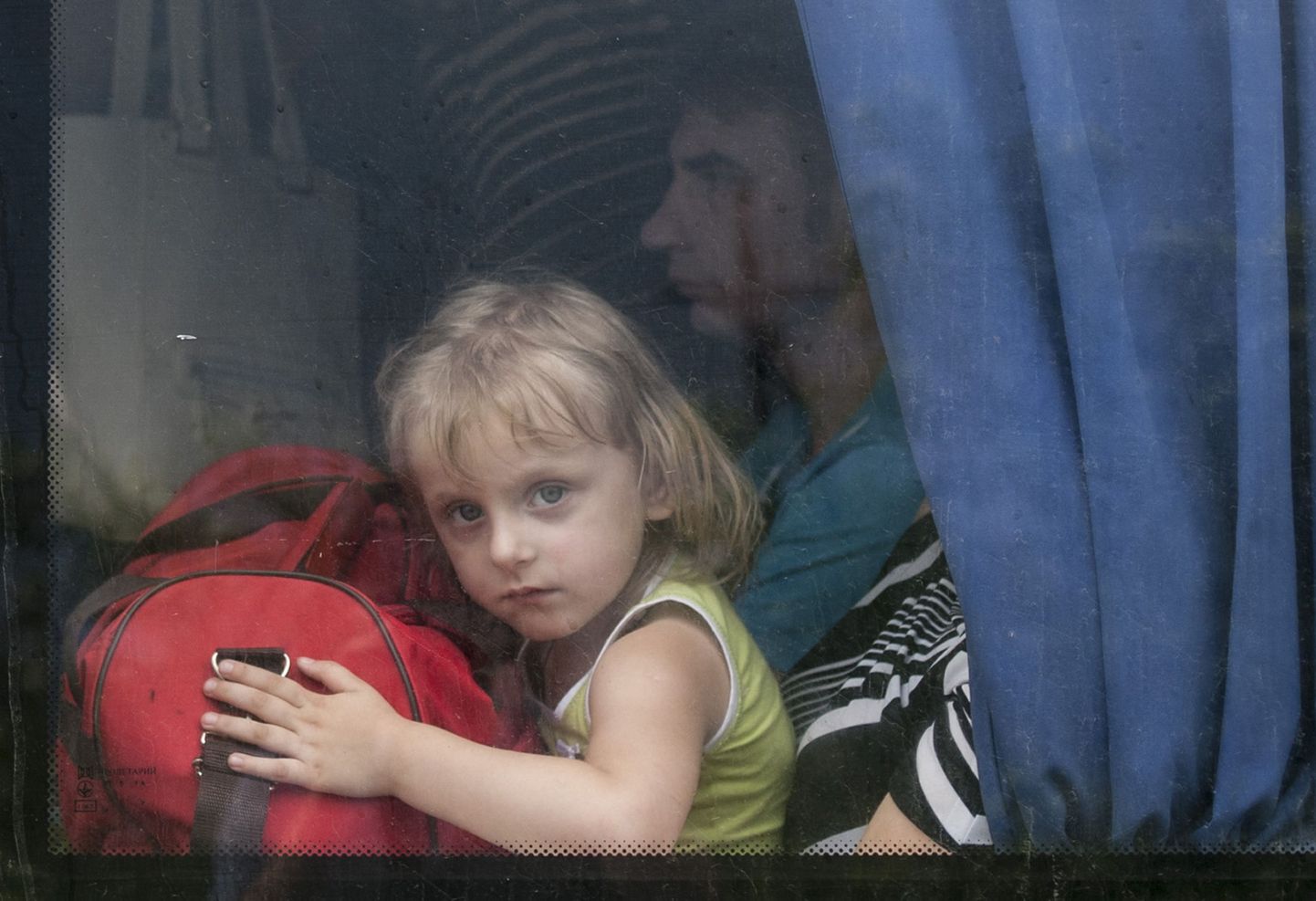 A girl looks out of a bus window, leaving Slovyansk, eastern Ukraine, Monday, June 9, 2014 after a mortar attack by Ukrainian government forces. Several buildings have been damaged by shelling in an eastern Ukraine city controlled by pro-Russian separatists, as the countrys president announced that negotiations are underway to bring the conflict to an end. (AP Photo/Evgeniy Maloletka) / TT / kod 436