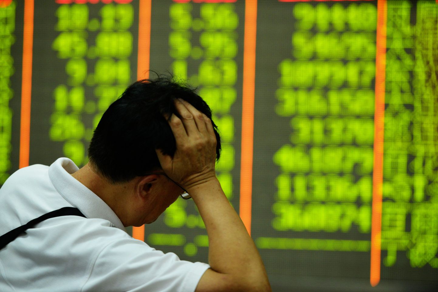 Investor vaatab aktsiate hindu Shanghai böril, kus rohelisega on tähistatud langevad aktsiad.