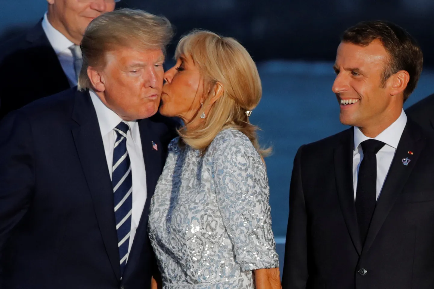 Брижит Макрон целует Дональда Трампа, чему больше рад президент Франции, чем президент США. Саммит G/, Франция, 2019 год.