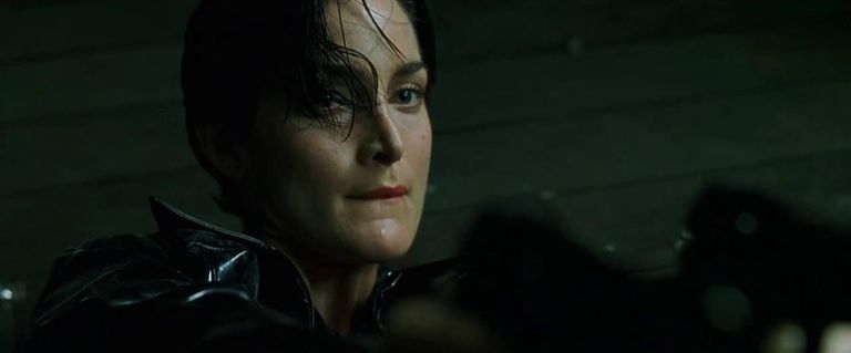 Trinity (Carrie-Anne Moss) põgeneb tehismaailmast kahe püstoli abil.