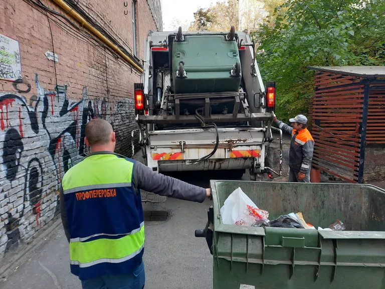 Viktor (vasakul) ja Mõkolai tühjendavad Kiievi kesklinnas prügikonteinereid, mille sisust moodustavad arvestatava osa raketirünnaku järel kokku koristatud klaasikillud.