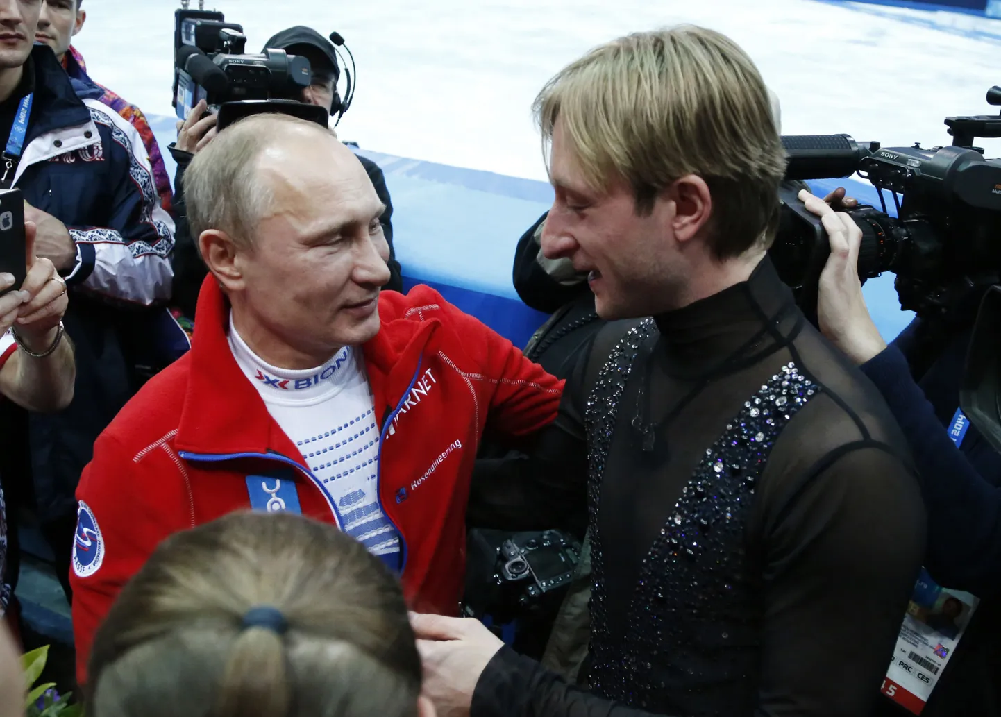 Президент РФ Владимир Путин поздравляет Евгения Плющенко после победы сборной России в командных соревнованиях Олимпиады по фигурному катанию.