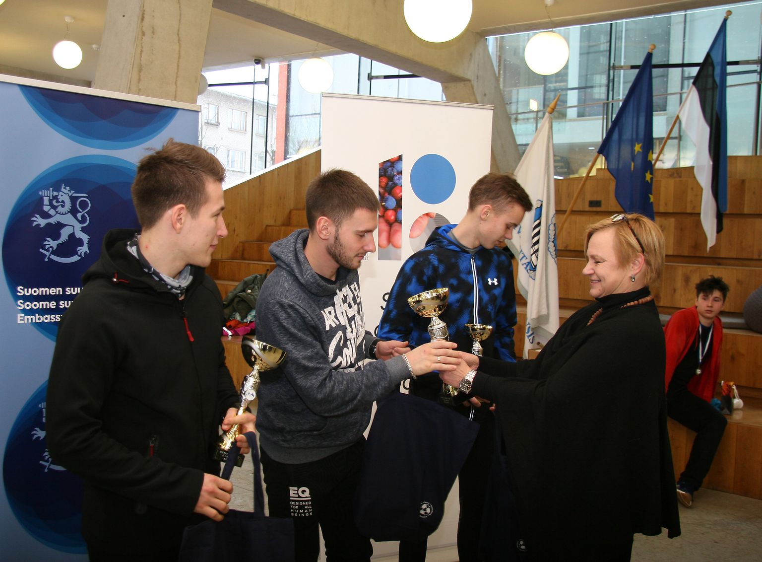 Ханнеле Валкеэниеми вручает кубок победителя первого забега Эскола Дмитрию Аристову.